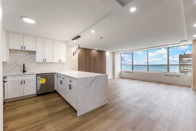 a large kitchen with a large window and stainless steel appliances