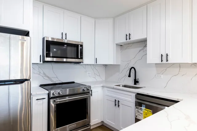 a kitchen with stainless steel appliances a stove microwave and sink