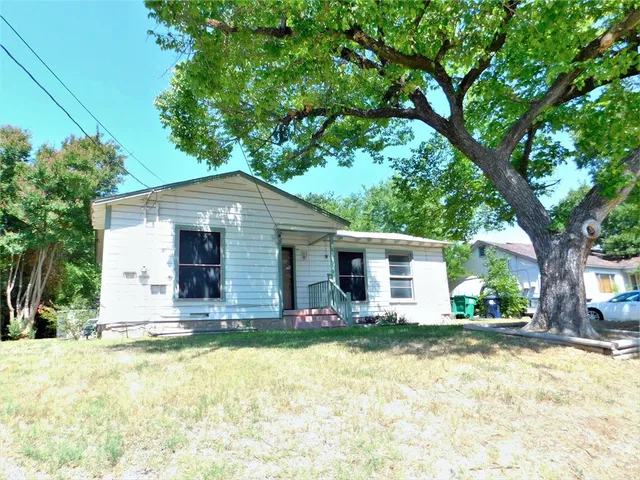 a front view of house with yard and trees around