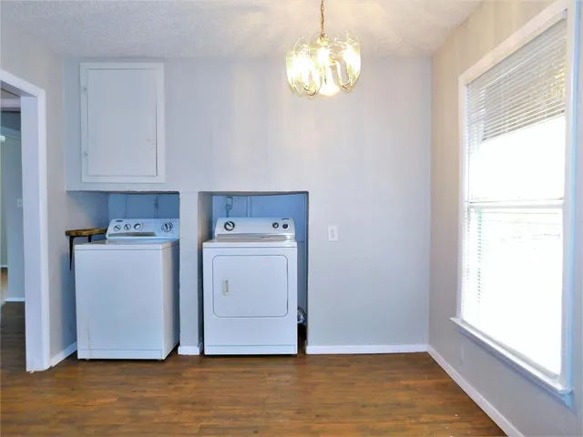 a view of cabinets and utility room with wooden floor