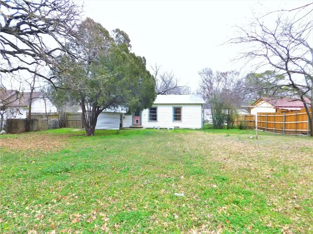 a view of a house with backyard and a tree