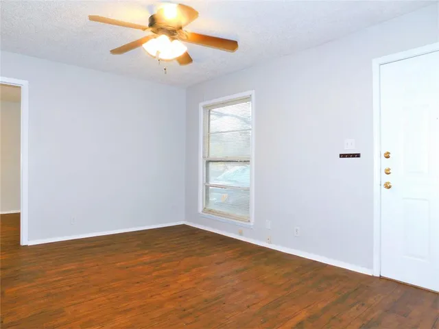 an empty room with a window and a fan