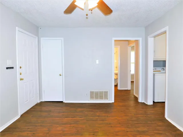 a view of empty room with wooden floor