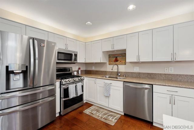 a kitchen with white cabinets stainless steel appliances and sink