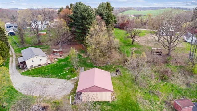 an aerial view of a house with a garden and trees