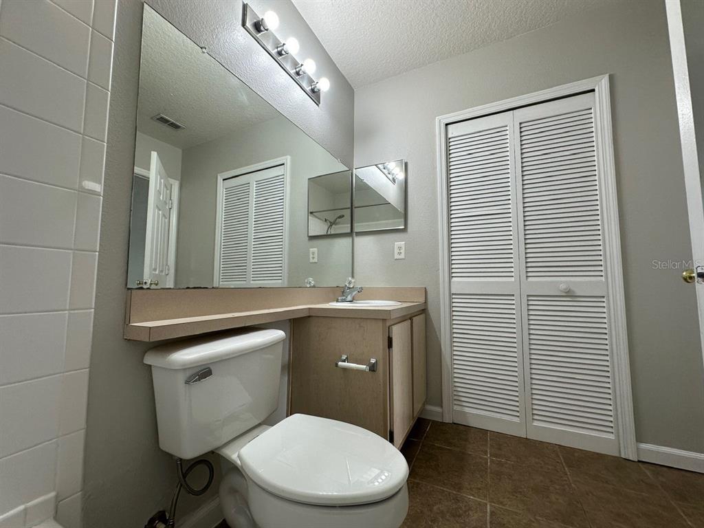 4348 South Kirkman Road, Unit 812 Orlando, FL 32811 - Photo 13 of 22 a bathroom with a toilet a sink and mirror