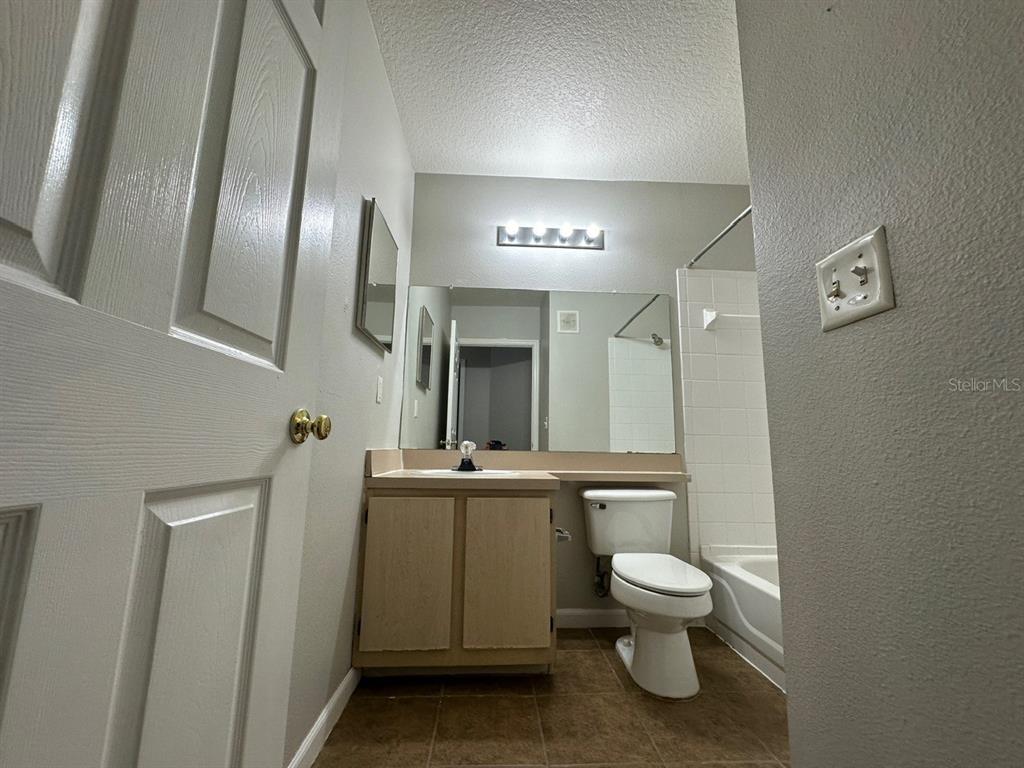4348 South Kirkman Road, Unit 812 Orlando, FL 32811 - Photo 17 of 22 a bathroom with a toilet sink and mirror