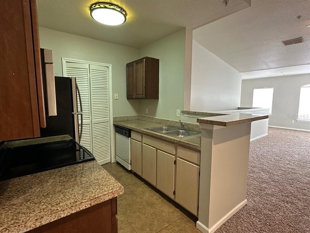 4348 South Kirkman Road, Unit 812 Orlando, FL 32811 - Photo 4 of 22 a kitchen with stainless steel appliances granite countertop a sink stove and refrigerator