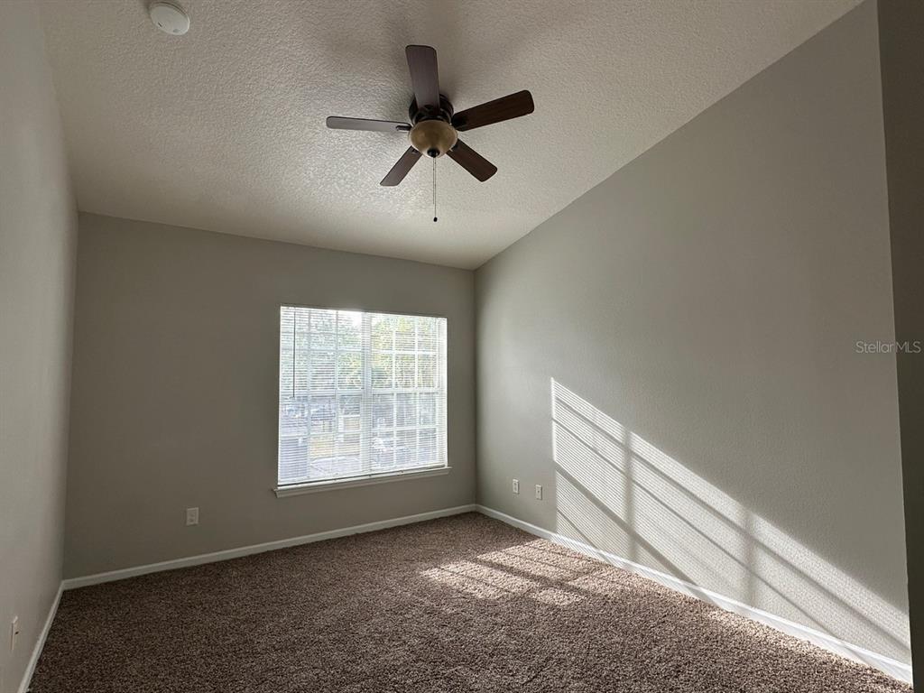 4348 South Kirkman Road, Unit 812 Orlando, FL 32811 - Photo 10 of 22 an empty room with windows and fan
