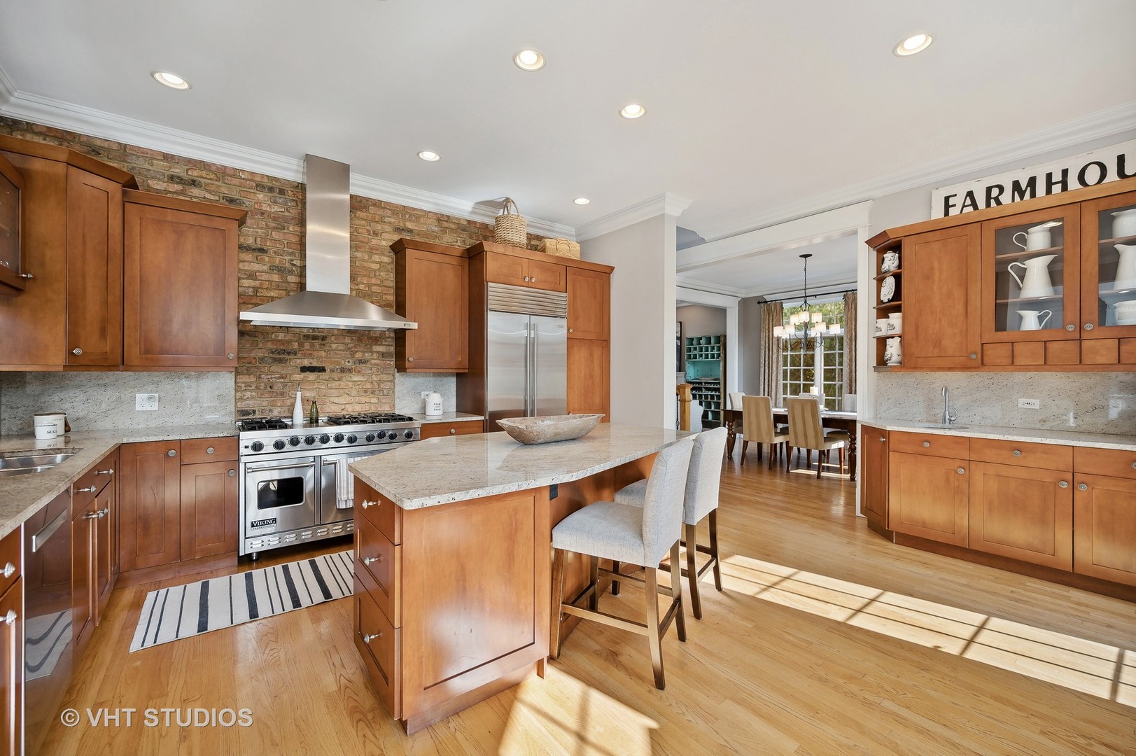 907 Queens Lane Glenview, IL 60025 - Photo 10 of 39 a kitchen with stainless steel appliances granite countertop a stove top oven a sink a dining table and chairs with wooden floor