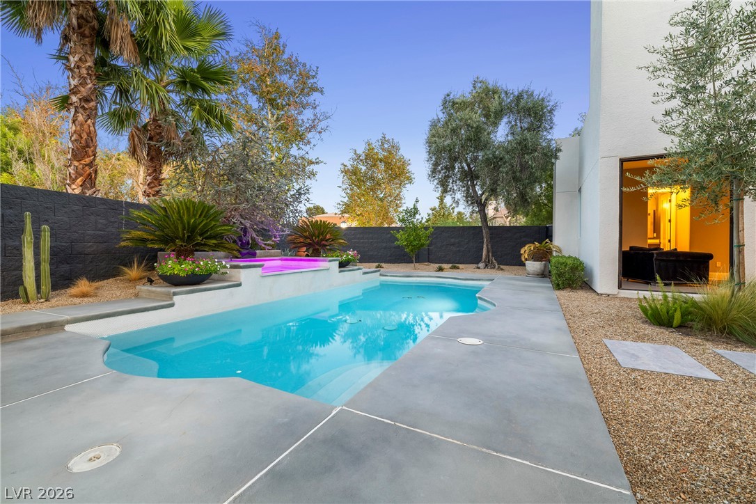 2000 Grouse Street Las Vegas, NV 89134 - Photo 56 of 89 An inviting backyard oasis offers a sparkling pool with an integrated spa, set amidst lush desert landscaping.