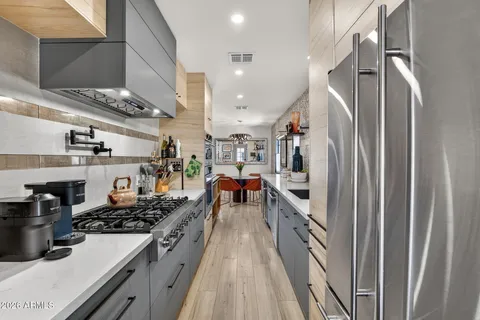 a kitchen with stainless steel appliances granite countertop a refrigerator and a stove