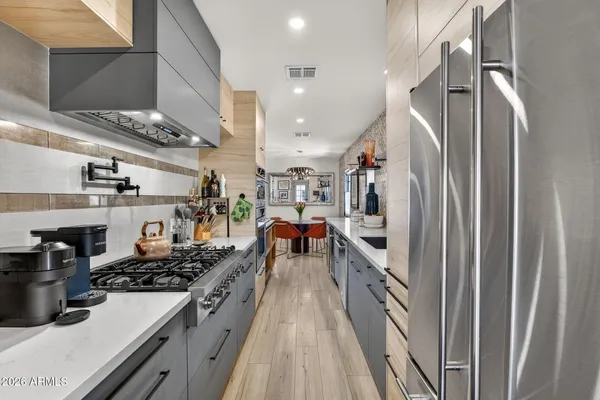 a large kitchen with stainless steel appliances granite countertop a lot of counter space and wooden floor