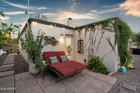 a view of a patio with table and chairs potted plants and floor to ceiling window