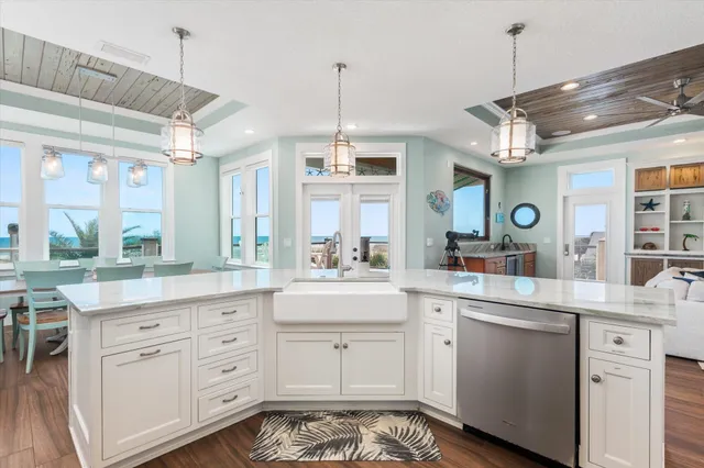 a kitchen with stainless steel appliances kitchen island granite countertop a table chairs and a wooden floor