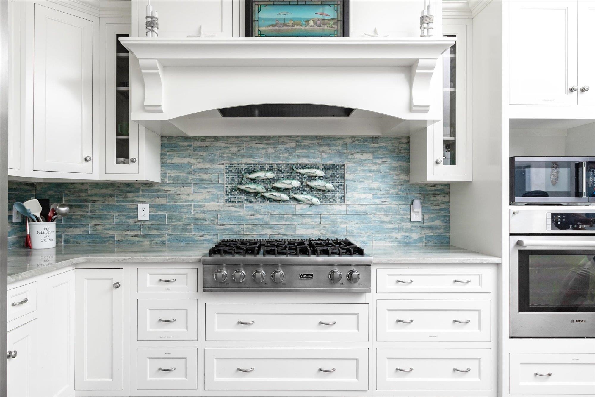 1 2nd Lane St. Augustine, FL 32080 - Photo 18 of 86 Kitchen featuring white cabinets, exhaust hood, stainless steel appliances, decorative backsplash, and light stone counters