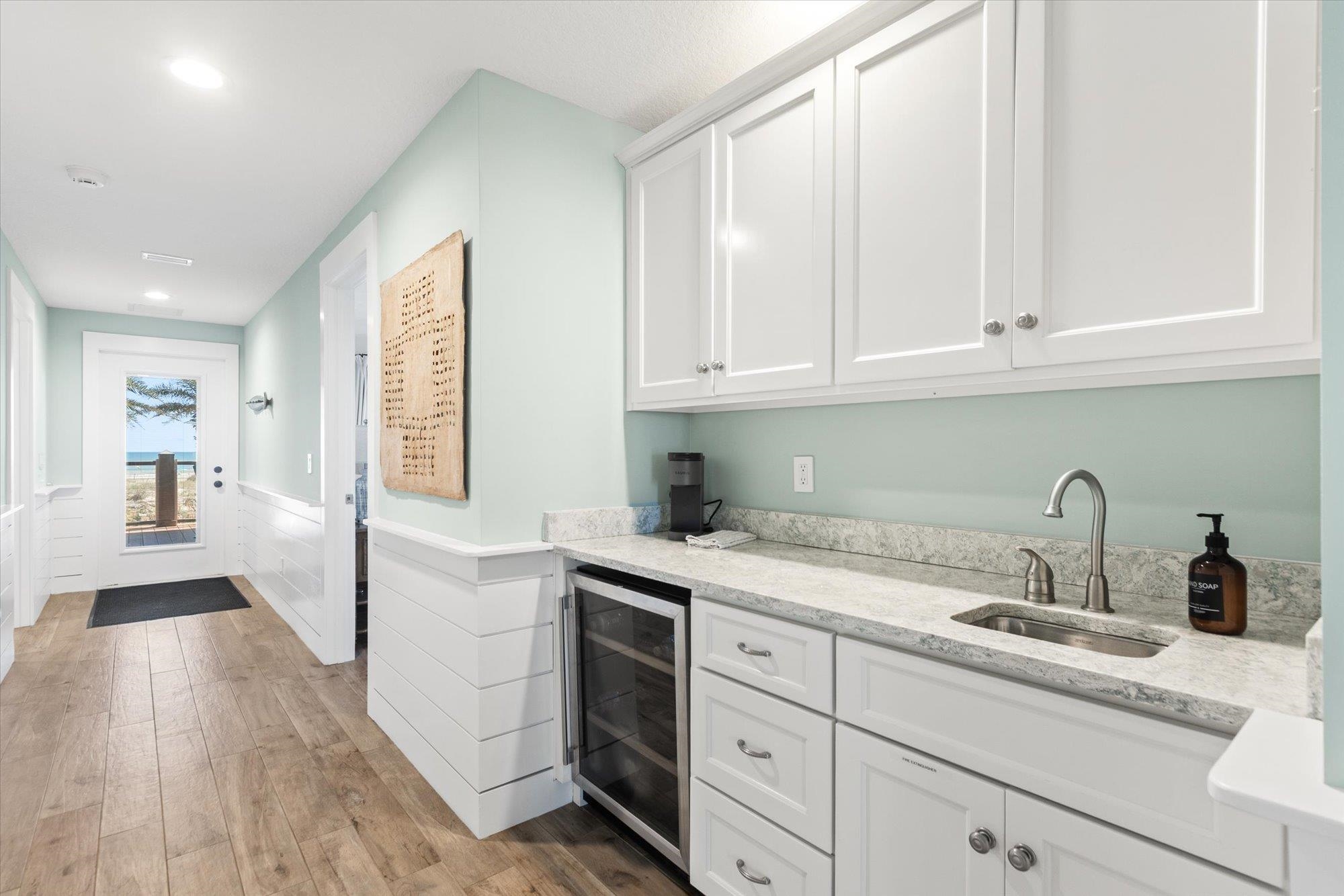 1 2nd Lane St. Augustine, FL 32080 - Photo 30 of 86 Bar featuring light stone countertops, white cabinets, a wainscoted wall, light wood-style floors, and beverage cooler