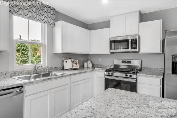 a kitchen with stainless steel appliances granite countertop a sink stove microwave and cabinets