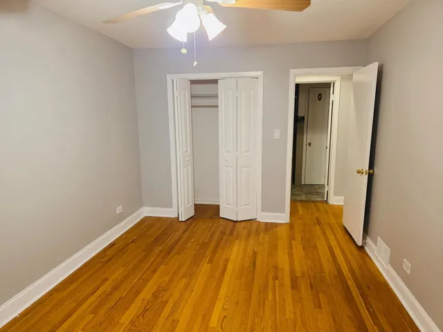 an empty room with wooden floor and sliding door