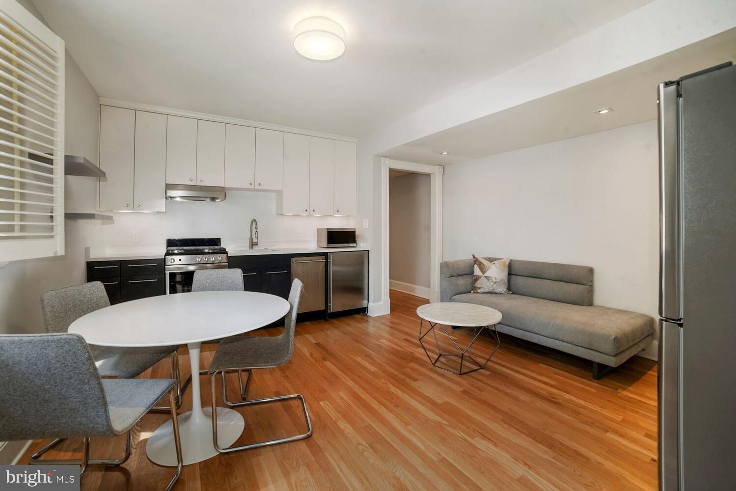 3348 Prospect Street Northwest, Unit 1 Washington, DC 20007 - Photo 2 of 16 a living room with furniture a dining table and kitchen view