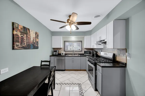 a kitchen with stainless steel appliances granite countertop a refrigerator a stove a sink dishwasher and a stove with wooden floor