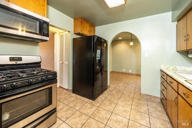 a kitchen with stainless steel appliances granite countertop a refrigerator and a stove