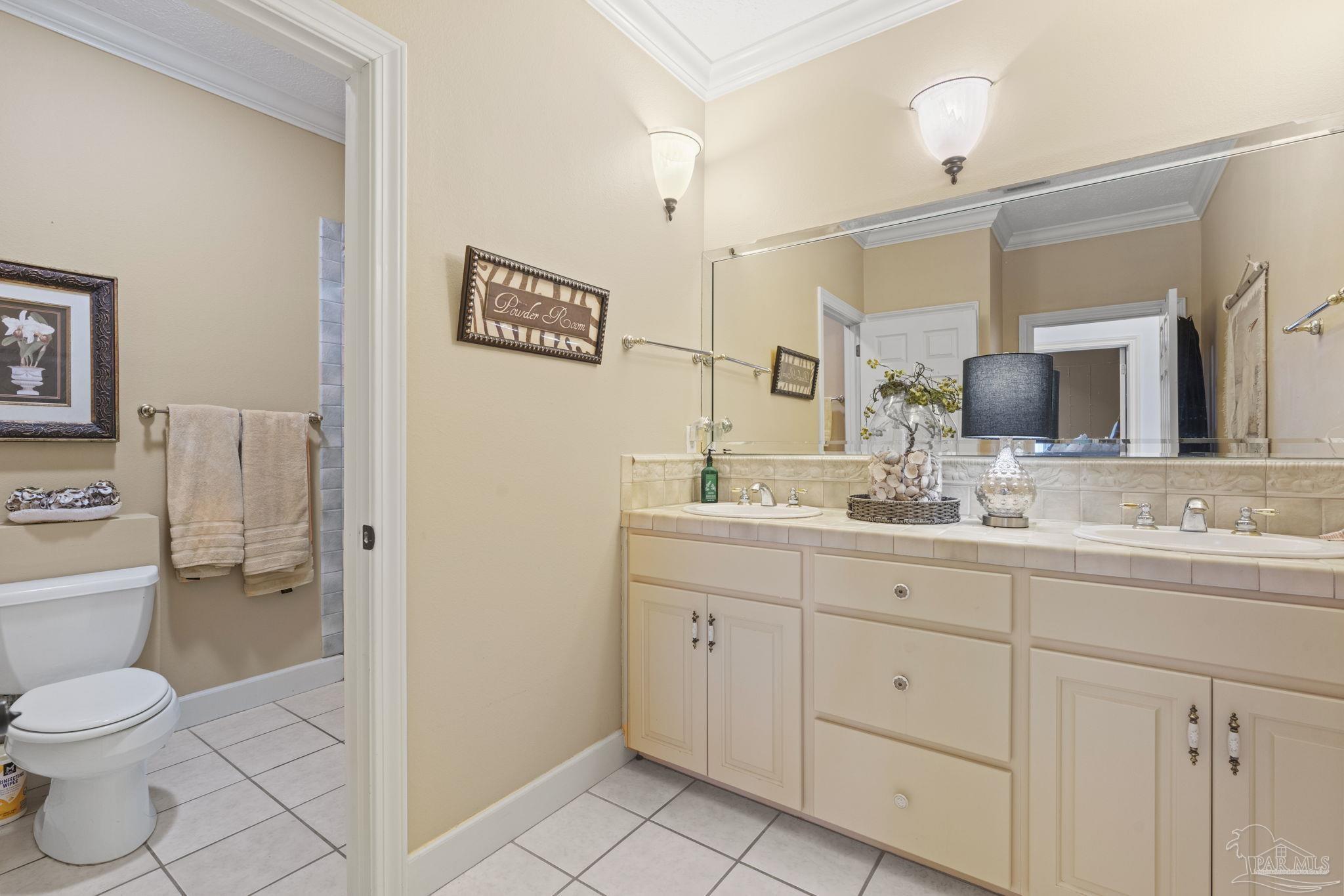 5460 North Shore Road Pensacola, FL 32507 - Photo 29 of 49 a bathroom with a toilet a sink a mirror and vanity