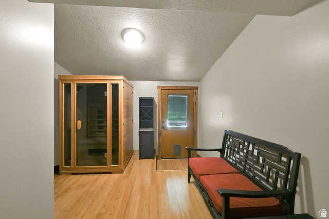 655 Ogden Canyon Road Ogden, UT 84401 - Photo 48 of 50 Hardwood-finish flooring throughout this room, featuring a built-in wood sauna with glass doors, a wood-paneled exterior door with a window, and overhead flush-mount lighting