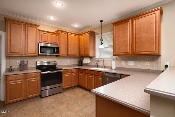 a kitchen with stainless steel appliances granite countertop wooden cabinets a stove a sink and dishwasher