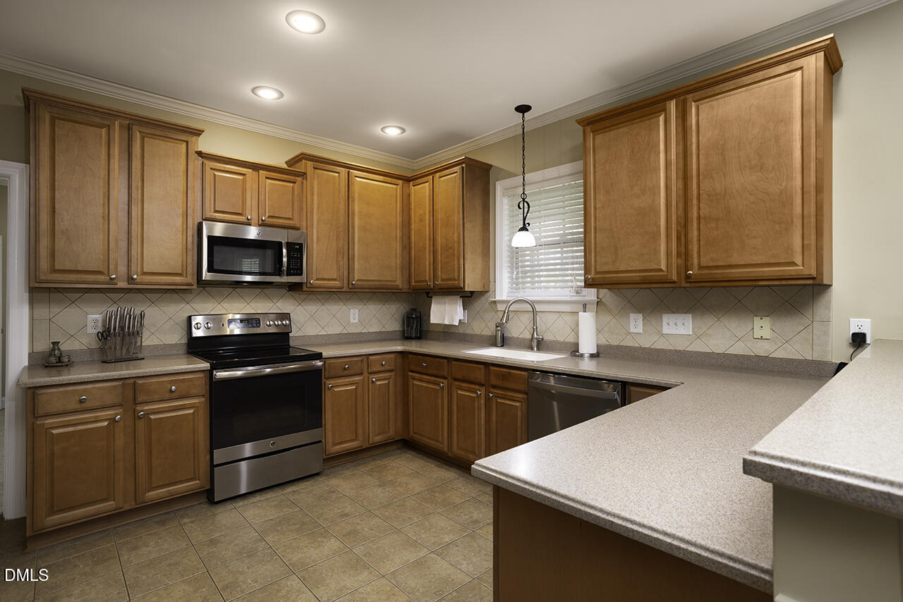 97 Bounty Circle Angier, NC 27501 - Photo 13 of 43 a kitchen with stainless steel appliances granite countertop wooden cabinets a stove a sink and dishwasher