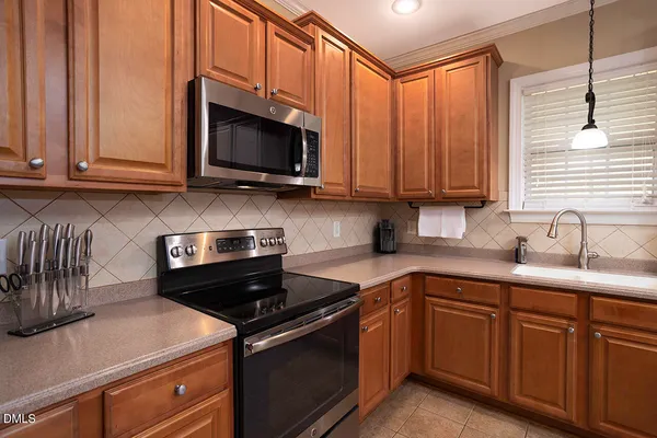 a kitchen with stainless steel appliances granite countertop a sink a stove and a microwave