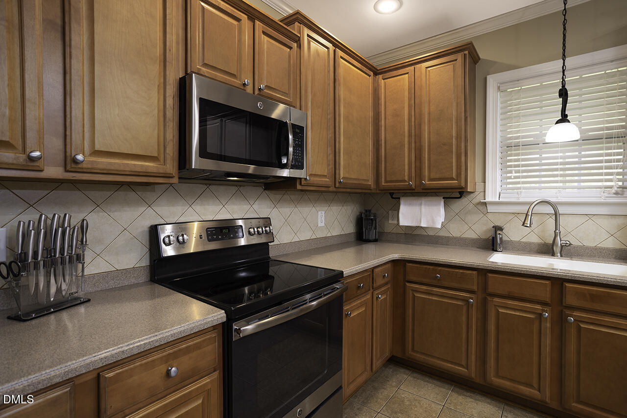 97 Bounty Circle Angier, NC 27501 - Photo 14 of 43 a kitchen with stainless steel appliances granite countertop a sink a stove and a microwave