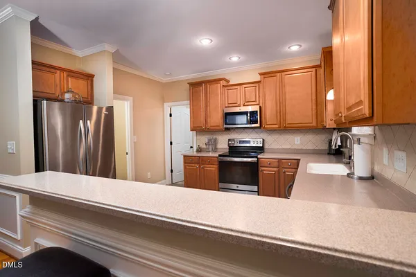 a kitchen with stainless steel appliances a refrigerator sink and microwave