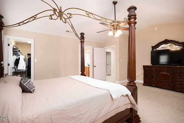 a bedroom with a bed and a flat tv screen on the dresser