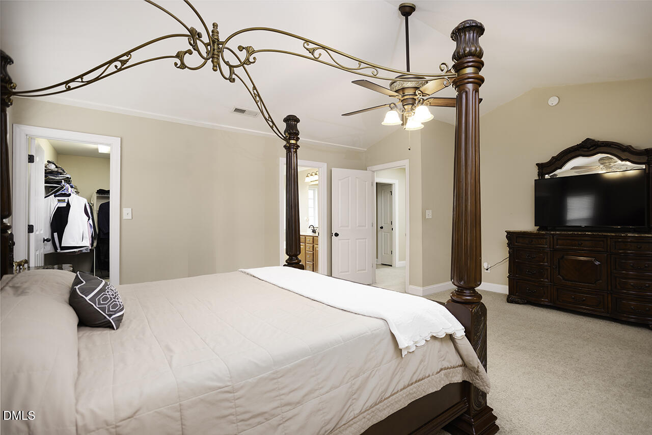 97 Bounty Circle Angier, NC 27501 - Photo 20 of 43 a bedroom with a bed and a flat tv screen on the dresser