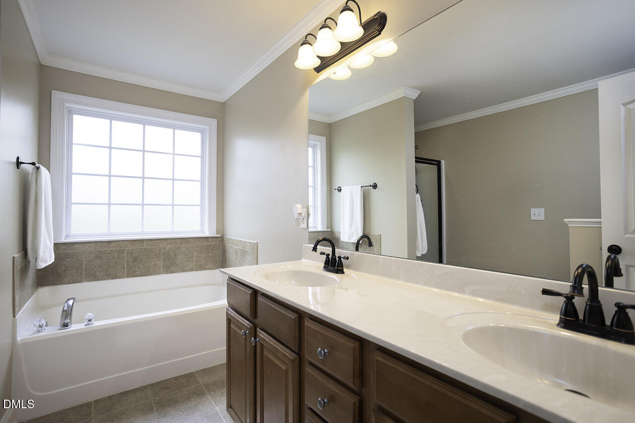 97 Bounty Circle Angier, NC 27501 - Photo 21 of 43 a bathroom with a tub a sink and mirror