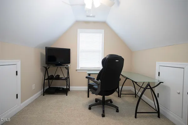 a view of a workspace with furniture and a window
