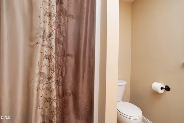 a white toilet sitting next to a shower curtain
