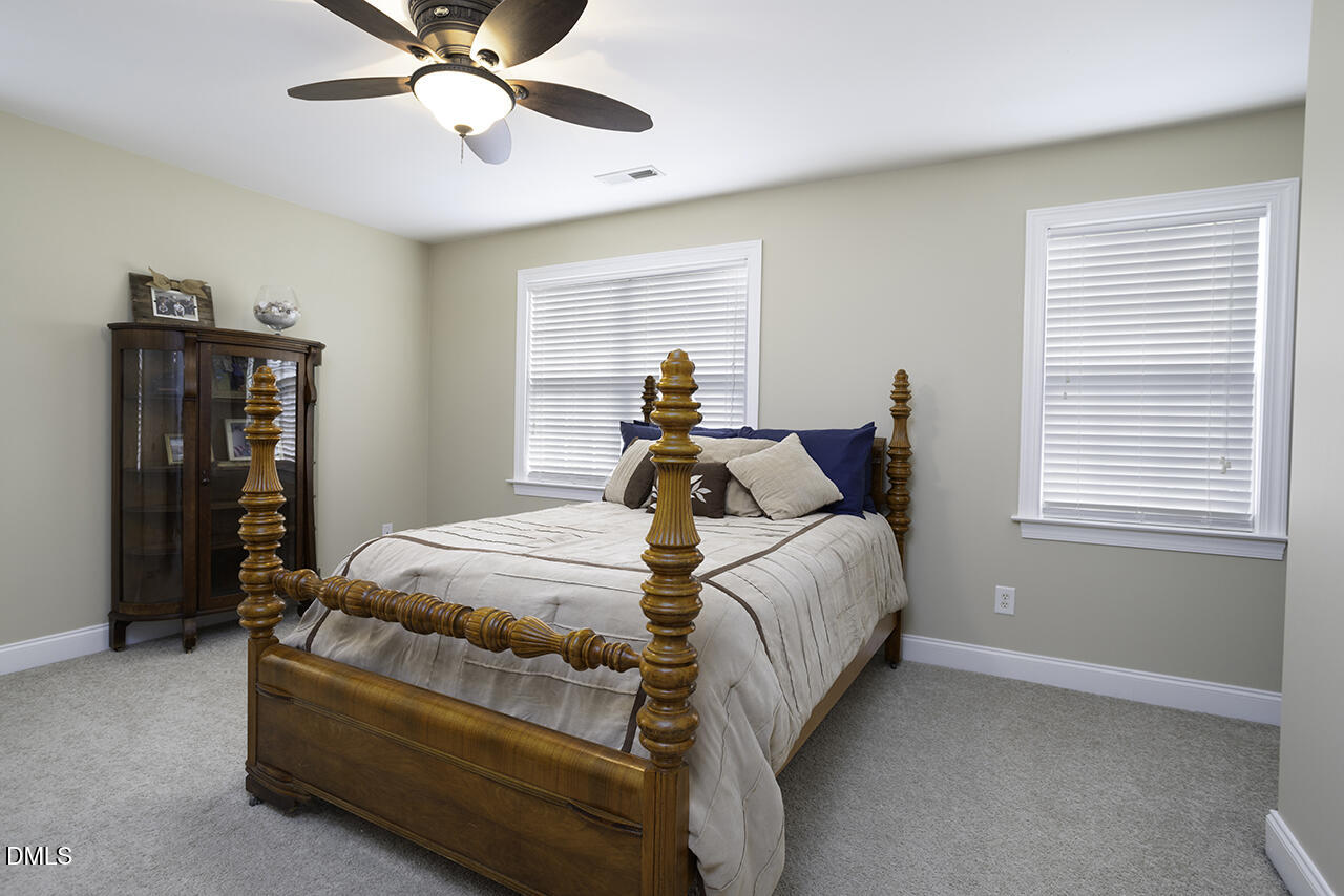 97 Bounty Circle Angier, NC 27501 - Photo 30 of 43 a bed room with a bed and a chandelier