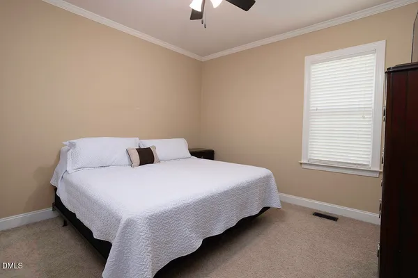 a bed sitting in a bedroom next to a window