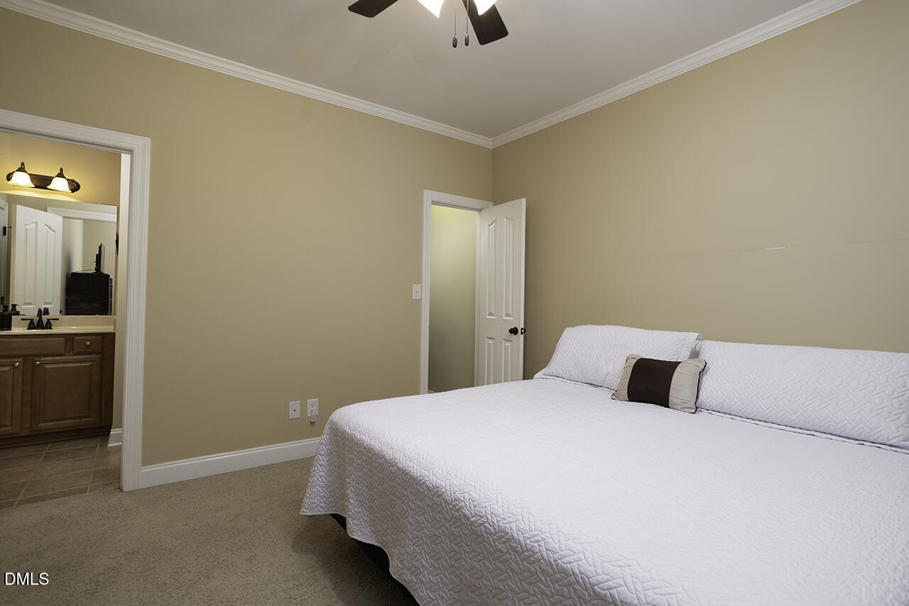 97 Bounty Circle Angier, NC 27501 - Photo 33 of 43 a bedroom with a bed and a chandelier