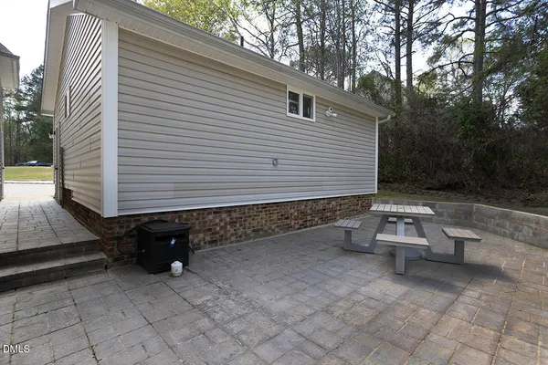 a backyard of a house with barbeque oven table and chairs