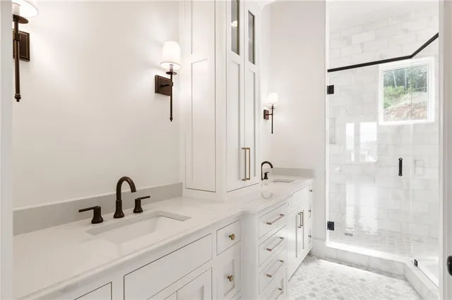 a bathroom with a double vanity sink mirror and shower