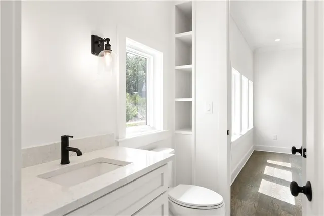 a bathroom with a sink a toilet and a window