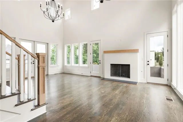 a view of a livingroom with wooden floor a fireplace and windows