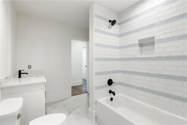 a bathroom with a sink a toilet a mirror and shower