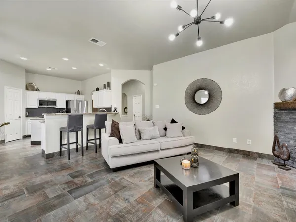 a living room with furniture and a view of kitchen