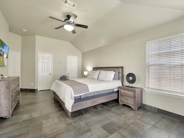 a spacious bedroom with a bed and window