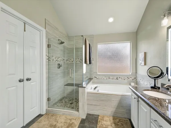 a bathroom with a granite countertop sink a mirror and shower