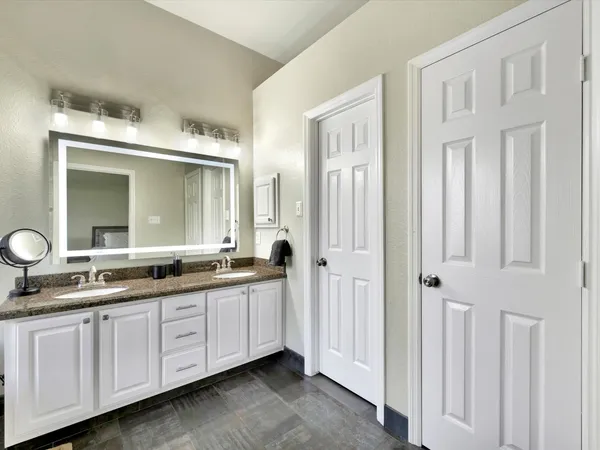 a bathroom with double vanity sinks a mirror and a shower